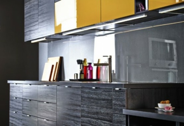 black counter punctuated yellow cupboards