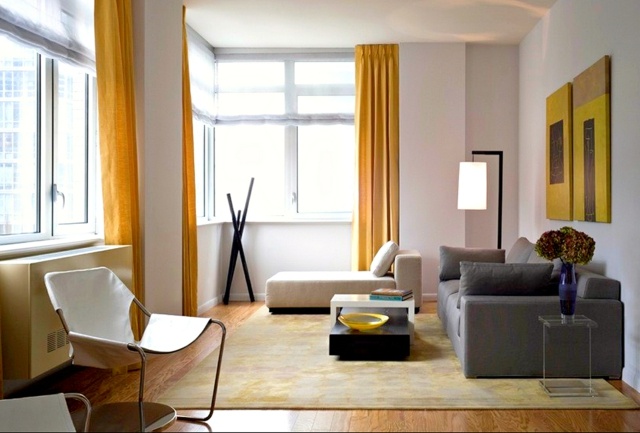 stue i minimalistisk stil gul gardiner gulvmatter hvit og gul gul malerier sofa grå deco blomster
