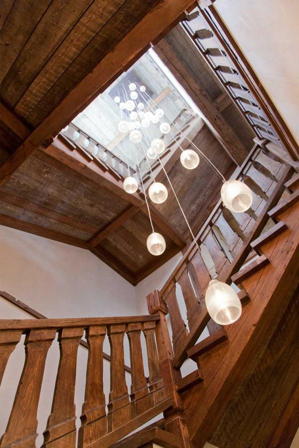 wooden staircase connecting floors suspended luminaire