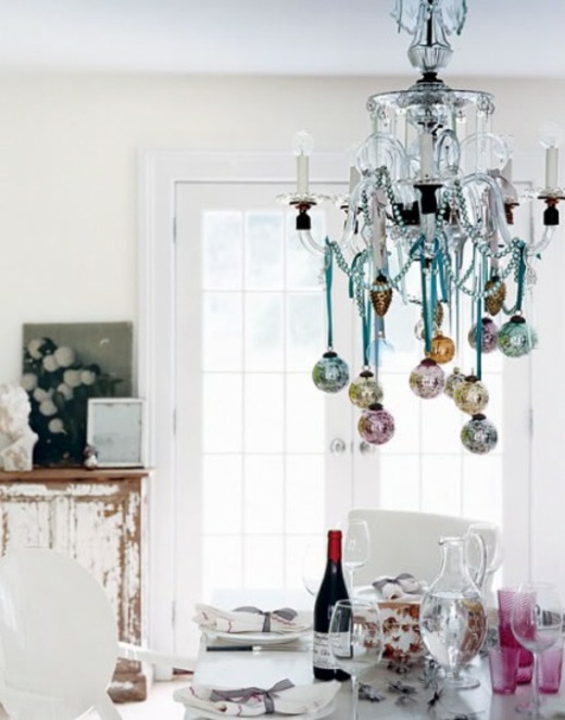 modern chandelier adorned with garlands and Christmas ornaments