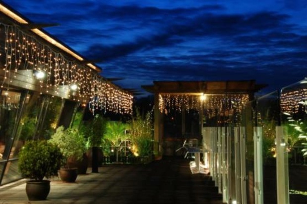 green terrace decked with light garlands